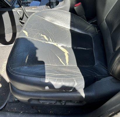 Before photo of torn leather driver seat