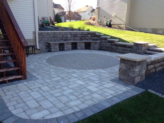 Paver patio with circle inlay. Built in seating benches around patio lite up at night with tons of LED outdoor lighting