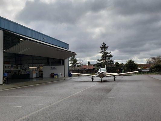 Piper Arrow in front of the hangar.