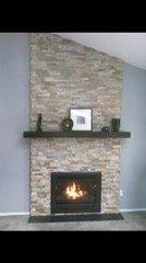 Gas Fireplace built-out into a chase, natural stone veneer, black marble hearth and custom wood mantel.