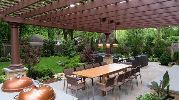 Backyard landscape renovation with custom fiberglass pergola, bluestone patio and outdoor kitchen.