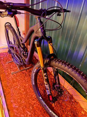 One of our top premieum carbon niner mountain bikes on display in a light box display. The bike is sitting on red mulch.