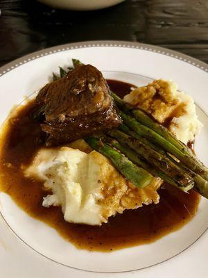 Braised beef with asparagus and a side order of mashed potatoes.