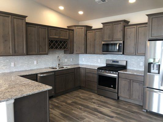 Staggered shaker stained cabinets with wine rack.