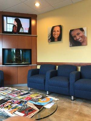 Waiting area with a TV, comfy chairs & magazines