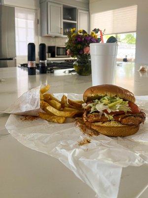 A barbeque chicken sandwich with fries