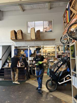 Interior of shop. You can see a few of the beautiful custom wooden bike cargo compartments up on the shelf above the register.