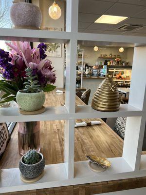 View of the bistro through a window with a gold ceramic bee hive.