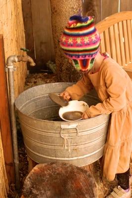 During outdoor play a kindergarten child has free access to water and dirt--important components in Waldorf curriculum.