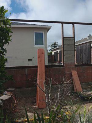 Wood fence being rebuilt with 2x4s & 4x4s framing, bolting to cement with  bolts and screws.