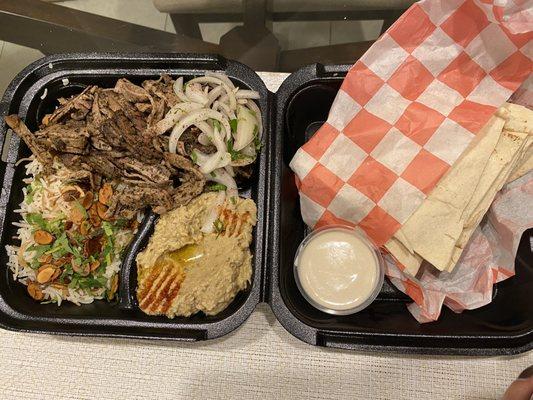 Lamb and beef platter with rice, baba ganoush, and pita.