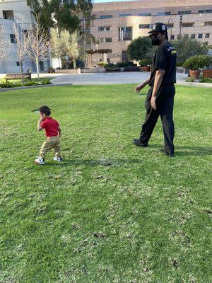 My son enjoying the sun and green grass! (That's not campus security lol that's dad)