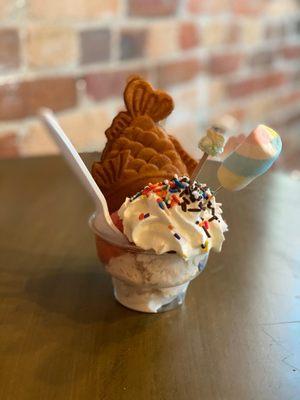 Strawberry ice cream in a fish cone