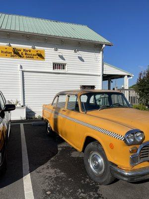 Outside. Cool vintage yellow cab!