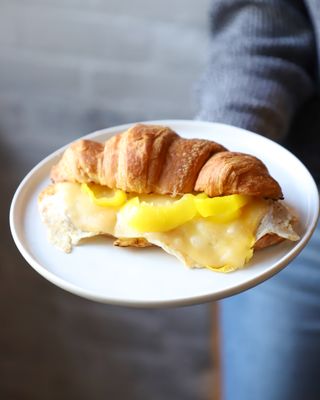 Breakfast croissant with sharp cheddar, banana peppers, fried egg, and special sauce