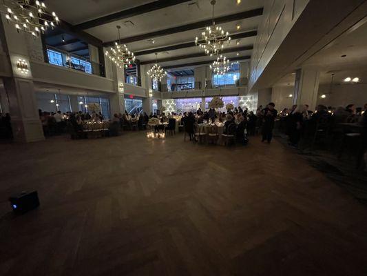 Long tables on left & right, round in the middle, bar in back, and dance floor.