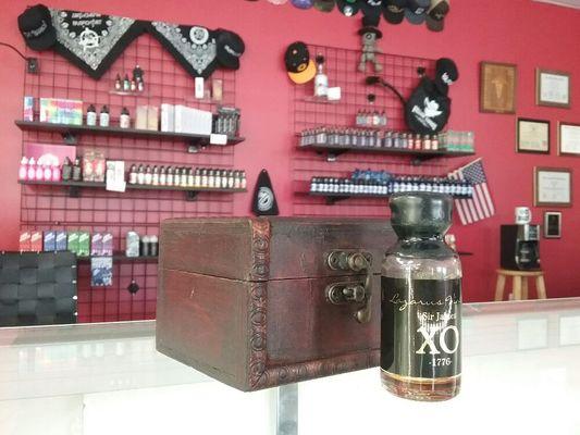 Lazarus vintage Sir James XO "the best chocolate in vape" -Docjr sitting in front of the right half of our liquid racks