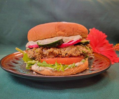 This nutrient-packed seared quinoa burger is topped with organic cucumbers, radish and tomatoe with a cilantro aioli drizzle.