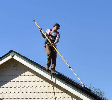 Crew member scrubbing panels clean with eco-friendly cleaning solution.