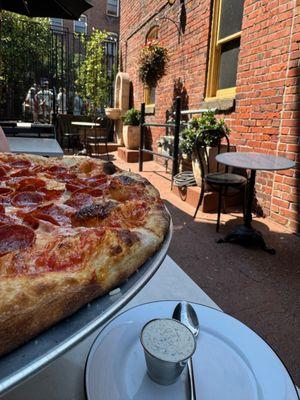 Pepperoni pizza with some seats and the fountain.