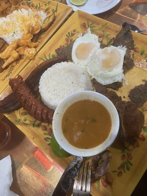 Bandeja paisa in front Back plate is a camarones dish