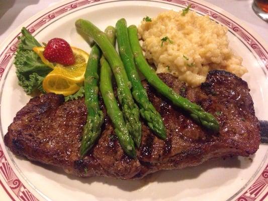 Medium-rare NY strip steak with cheesy risotto and asparagus.