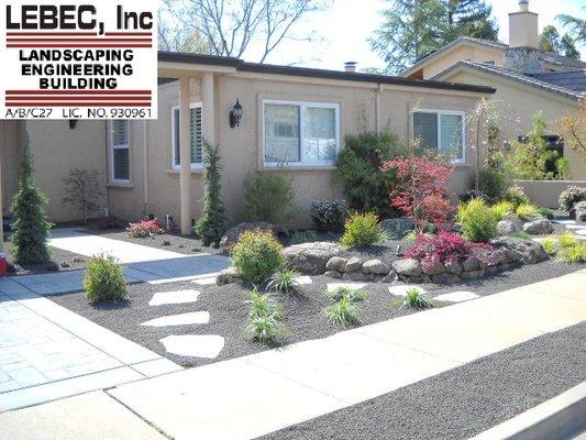 Black concrete, layered rock walls and landscaping.