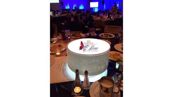 This centerpiece features translucent vinyl applied on sides and top of glass vase. A lit base on bottom adds a glow effect.