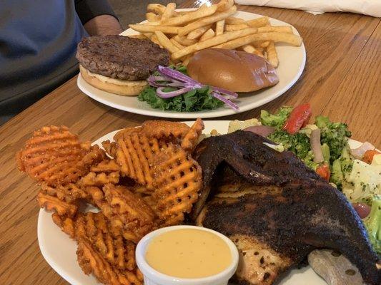 Honey glazed smoked half chicken with waffle fries (front) and a burger (back).