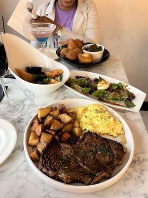 Ribeye steak and eggs with home fries.