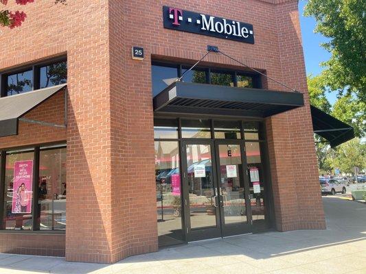 Exterior view of entrance. Little white signs on doors simply state, "T-Mobile is here for customers."