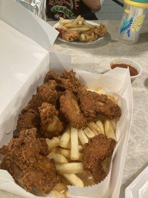 Foreground: 12-piece Chicken Wings and Fries. Background: half of 4-piece Chicken Strips and Fries.