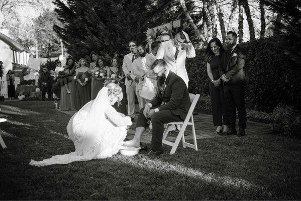 Foot washing ceremony at barn on bridge.