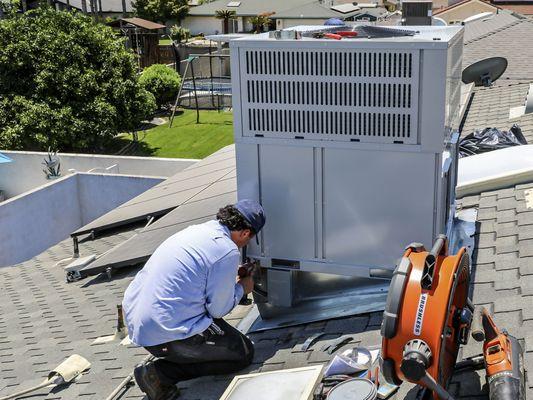 All Climate Air installation technician putting the final touches on a new package unit.