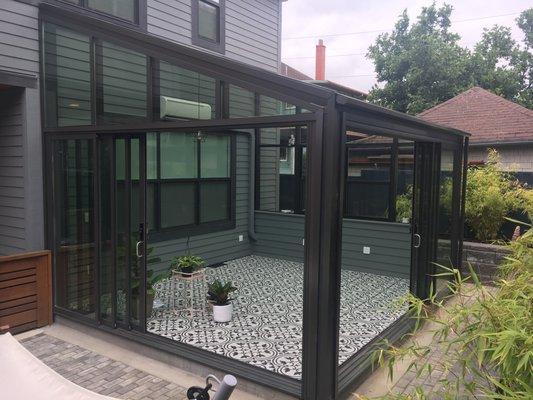 Shed style sunroom with retractable glass walls.