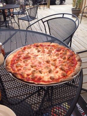 Large sausage pizza, lovely outdoor dining