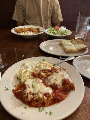 Pasta Trio nearest Fettuccine Alfredo w/fried chicken Garlic breadsticks to the right