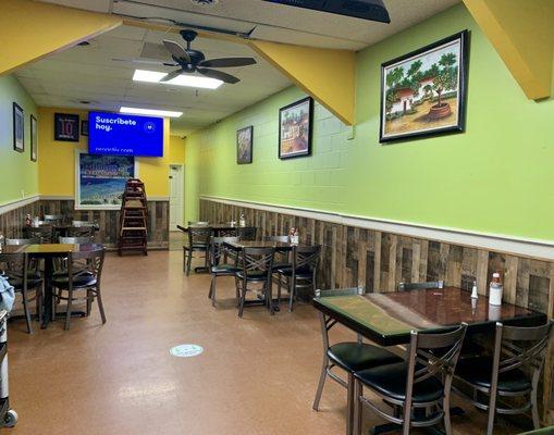 Inside. Standing by the cash register looking toward back of restaurant. Several 4-top tables behind me.