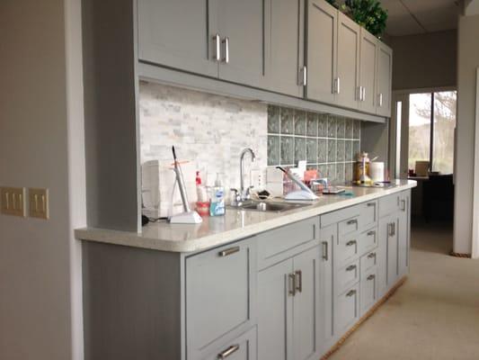 Cabinets have been refaced and finished in a simple yet bold grey. The tile backsplash at left created a great accent.