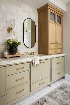 Remodeled primary bathroom with quartzite countertop,  custom cabinetry, white oak spa tower & stone mosaic floor