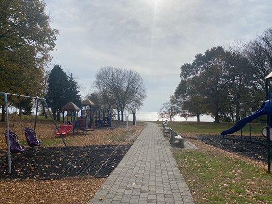 Walkway down to beach with playground equipment on both sides.