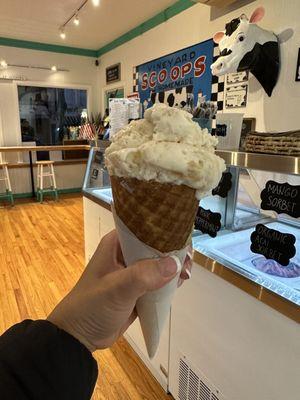 Strawberry cheesecake ice cream on a homemade waffle cone