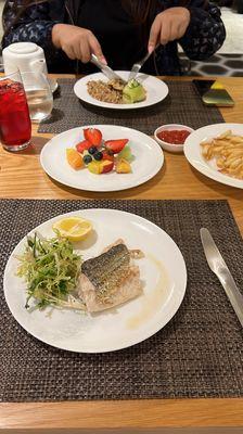 Fresh fruits, grilled sea bass, chicken with brown rice and French fries in the restaurant @ the first class lounge.