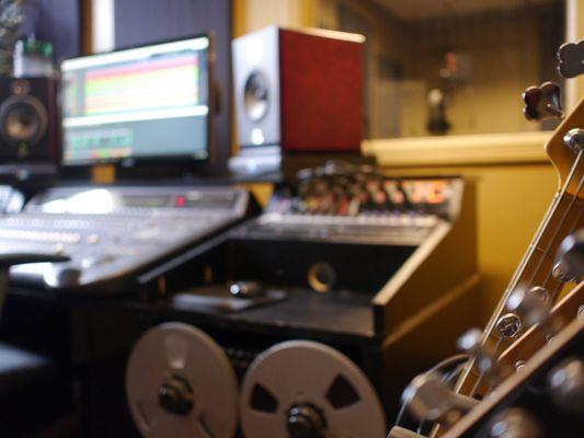 Control room from guitar rack w/ active musicman bass and custom electric and acoustic guitars. Avalon VT737SP w/vintage tubes not pictured.