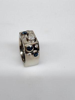 Custom design bezel set diamond ring with color matched blue diamonds