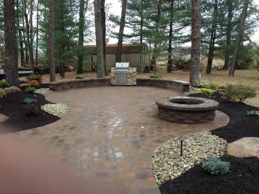 Beautiful patio with a seating wall, fire pit and a complete surrounding landscape design so you can enjoy your back yard.