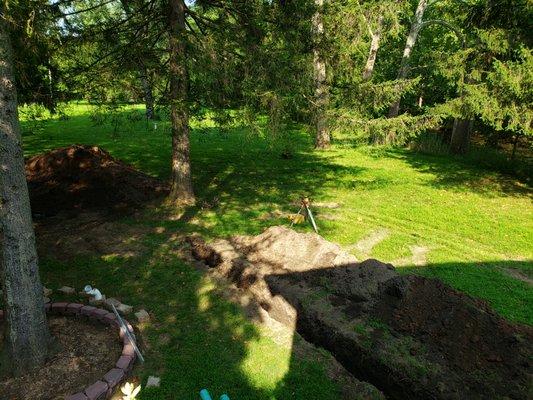 Excavating the trench from the home to the new septic tank