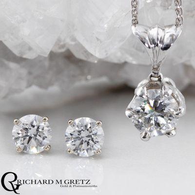 Diamond solitaire pendant and diamond stud earrings in 14kt white gold.