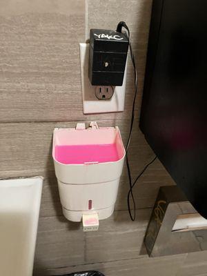 soap dispenser with no lid, graffiti on the toilet cover holder & on the adapter in the outlet