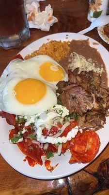 The chilaquiles plates with sunny side up egg and added carnitas.